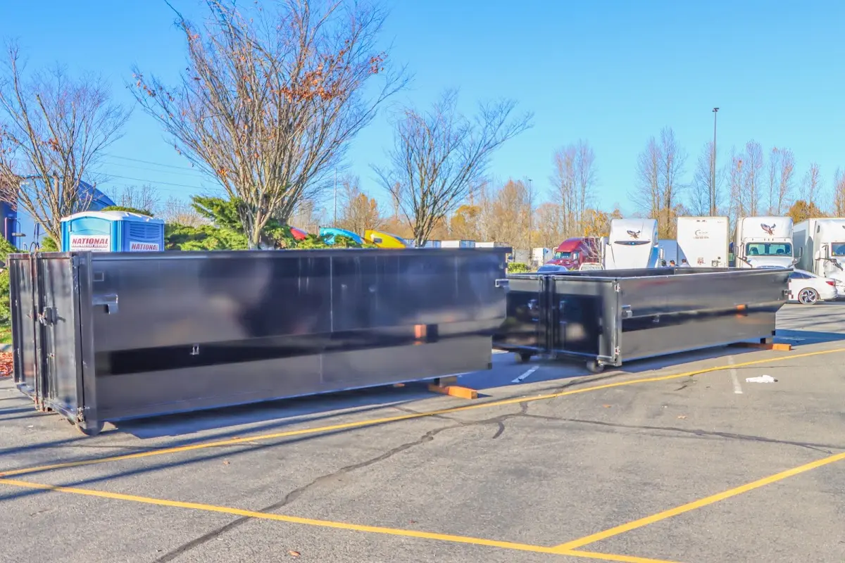 Professional dumpster rental service with roll-off container on residential driveway in Halfway